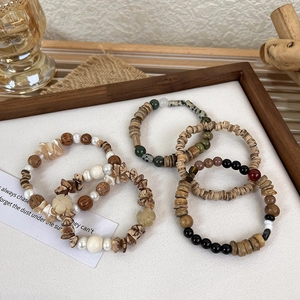 Detail of bohemian stretch bracelets set featuring natural wood beads and pearls