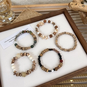 Detail of vintage beaded bracelets featuring baroque pearls, shells, and natural wood beads
