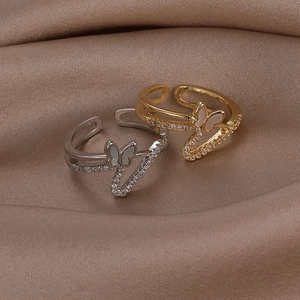 Macro shot of gold and silver butterfly rings with shell inlay and cubic zirconia stones