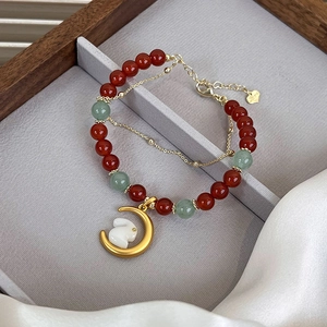 Detailed view of beaded double-layer bracelet with golden moon and white rabbit charms