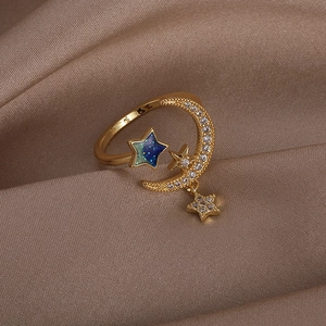 Macro shot of celestial moon ring with blue star inlay on a champagne silk fabric