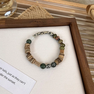 Detailed close-up of mixed beads bracelet with wood, marble and baroque pearls