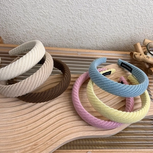 Cerchietto in maglia spessa per donna in vari colori su espositore in legno
