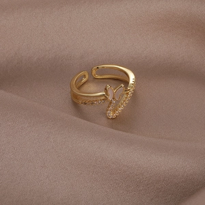 Detail of a golden double-layered butterfly ring with pink enamel and sparkling zircons