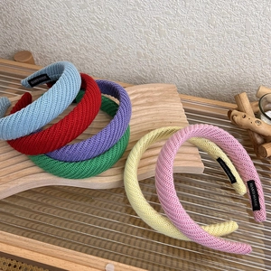Dettaglio della trama a maglia delle fasce per capelli con etichette fatte a mano colorate