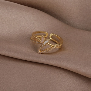 Detailed macro view of a gold butterfly ring with shell inlay and zircon wave band