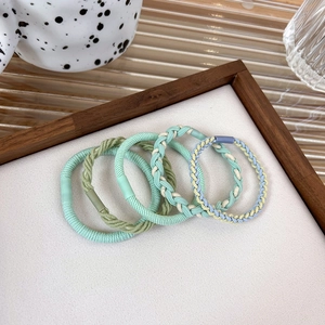 Detailed set of 5 pastel braided elastic hair ties displayed on a minimalist wooden tray