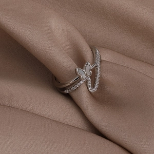 Detailed macro of silver double-layered butterfly ring with shell and zircon inlay