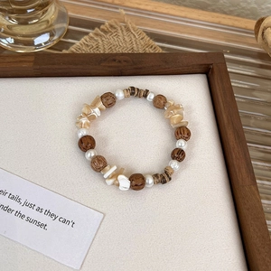 Detailed close-up of retro beaded bracelet with wooden beads, pearls and shell fragments