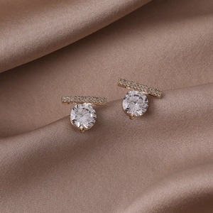 Vue macro de boucles d'oreilles en argent S925 avec zircon sur tissu en satin champagne