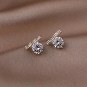 Vue macro des boucles d'oreilles en argent S925 doré avec zircons sur un tissu en soie