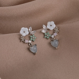 S925 silver needle floral earrings with zircon stones and heart pendants on brown satin