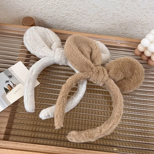 Detail of plush rabbit ear headbands in beige and brown with soft fuzzy texture