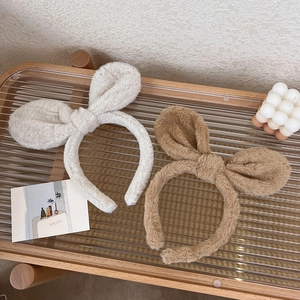 Detail view of plush bunny ear headbands in beige and dark brown soft faux fur texture