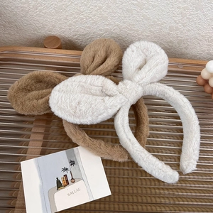Close-up of soft plush rabbit ear headbands in light brown and beige colors
