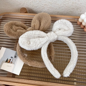 Detail of plush rabbit ears and bow headbands in soft brown and white fuzzy fabric
