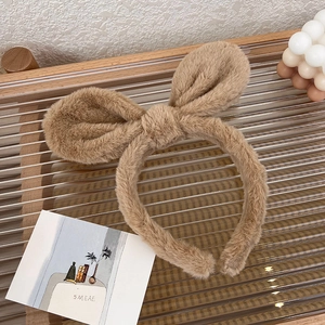 Close-up of brown plush bunny ear headband with soft fabric texture and bow detail