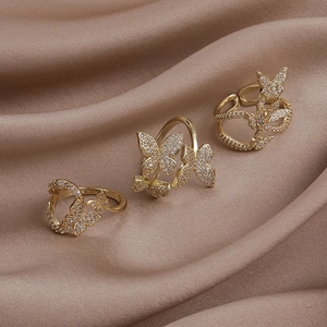 Exquisite gold-plated butterfly zircon rings set on elegant champagne satin backdrop