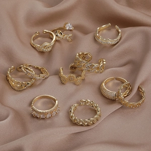 Ensemble de bagues dorées élégantes avec zircon sur fond de satin champagne