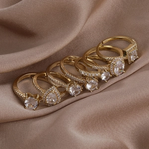 Macro shot of gold adjustable ring set with various zircon shapes on luxury silk fabric