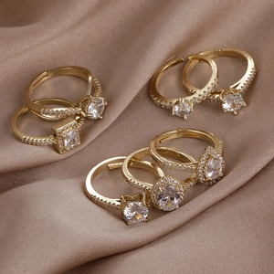 Detail of seven gold-plated adjustable rings with multiple cubic zirconia shapes on silk