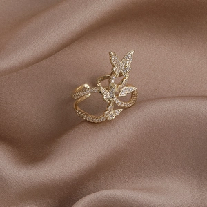 Detailed view of adjustable gold butterfly ring with cubic zirconia on champagne silk