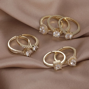 Macro shot of 18K gold open rings with various CZ shapes on brown silk fabric