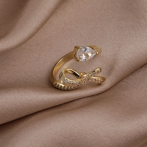 Détail d'une bague dorée ajustable avec zircon poire et nœud papillon étincelant
