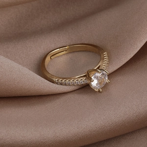 Close-up of golden adjustable ring with a large zircon centerpiece and micro-pave setting
