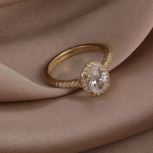 Macro detail of a golden halo ring with oval cubic zirconia and micro-pave diamonds