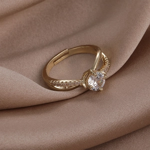 Detailed shot of golden crossover ring with large round zircon and pavé crystal accents