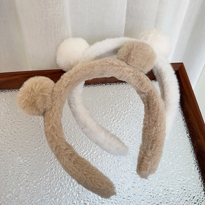 Vue détaillée des bandeaux oreilles d'ours en peluche kaki et beige sur plateau argenté