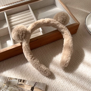Détail du serre-tête oreilles d'ours en peluche kaki doux sur un support en bois chic
