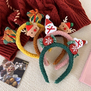 Detail of plush Christmas headbands with deer antlers and holiday characters in cozy setting