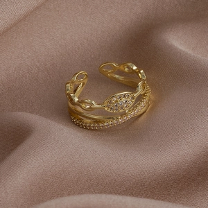 Dettaglio dell'anello dorato a doppio strato con zirconi e pietra a forma di marquise