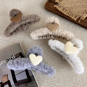 Detailansicht von vier flauschigen Herz-Haarklammern in Braun, Beige, Grau und Weiß