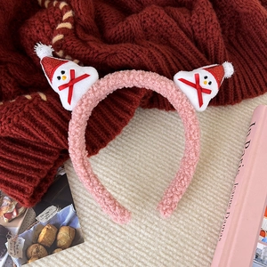 Close-up of pink plush Christmas headband featuring snowman with sequins and red bows
