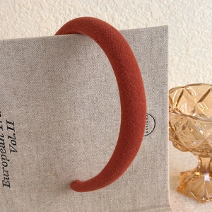 Detail view of the rust red plush headband with twill texture and thick sponge padding