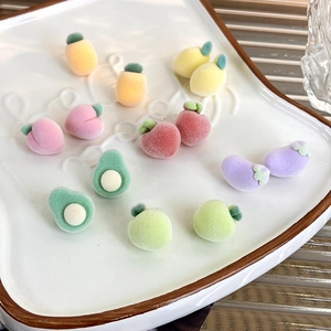 Close-up of sweet flocked fruit and vegetable studs showing soft fuzzy peach and avocado details