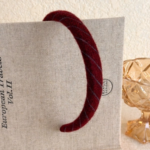Detailed macro view of the vintage burgundy velvet headband with elegant striped texture