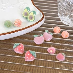 Detailed view of flocked fruit stud earrings with soft velvet texture and cute peach design