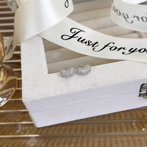 Close-up of heart-shaped stud earrings with micro-pave cubic zirconia in gift packaging