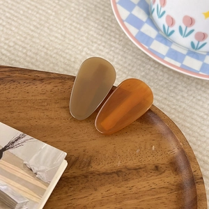 Gros plan de barrettes en acrylique en forme de goutte aux tons café et ambre