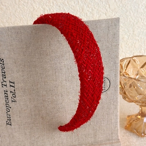 Detailed macro view of vintage red woven tweed headband texture with fringe edges