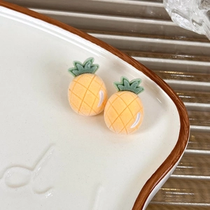 Macro detail of sweet flocked pineapple stud earrings with vibrant yellow velvet texture