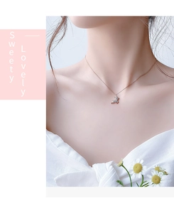 Gros plan du collier biche en finition or rose et zircon sur le mannequin