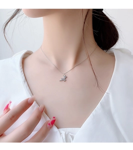 Gros plan d'un collier pendentif renne argenté scintillant porté sur la clavicule