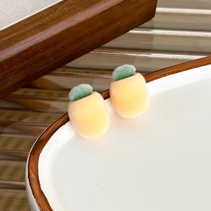 Macro view of flocking texture on yellow pineapple-shaped stud earrings