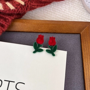 Detailansicht der beflockten roten Tulpen-Ohrringe mit grünen Blättern auf dem Pullover