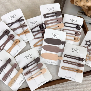 Detail of matte coffee brown hair clips in various geometric shapes on display